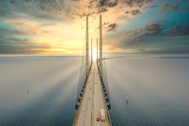 A beautiful aerial view of a sunset through the Oresund bridge between Denmark and Sweden A beautiful aerial view of a sunset through the Oresund bridge between Denmark and Sweden over the Oresund Straight oresund bridge stock pictures, royalty-free photos & images