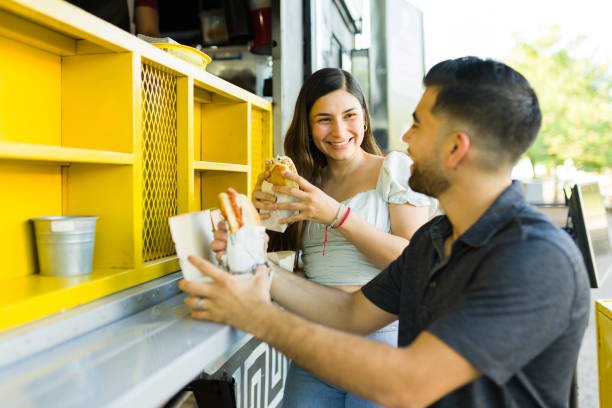 istock Cheerful couple looking excited eating a delicious sandwich 1437526073