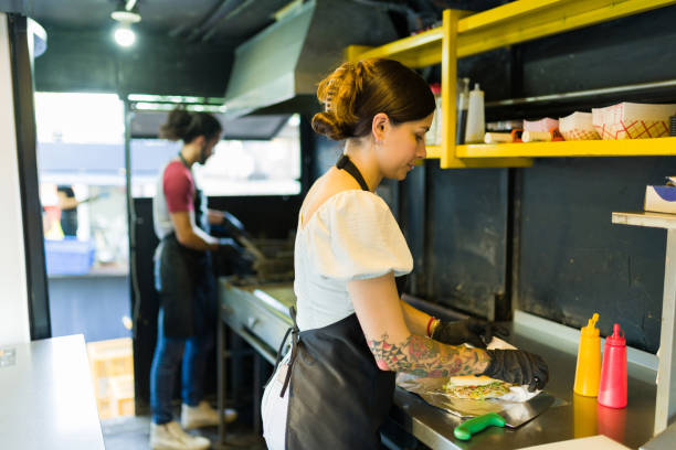 Female cook ready to serve fast food for a customer