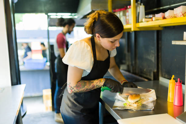istock Attractive woman chef preparing a fast food sandwich 1437526154