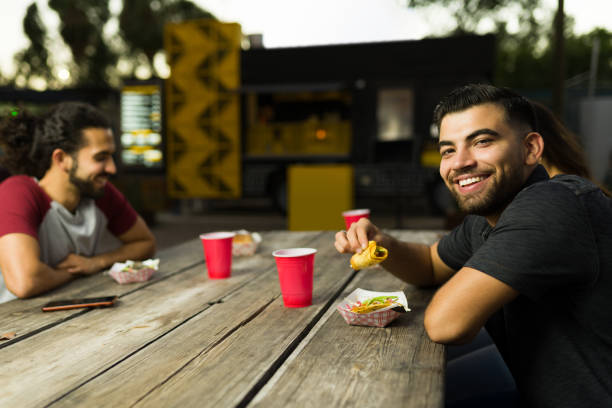 istock Attractive hispanic man enjoying eating mexican tacos 1437527299