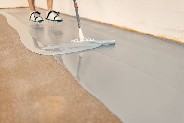 istock Construction worker apply grey epoxy resin in an industrial hall 1437527609