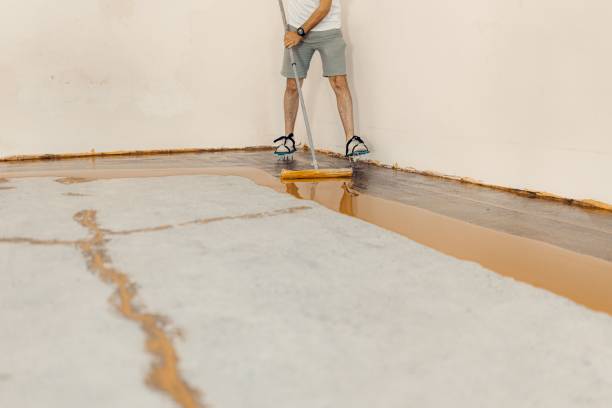 istock Worker applying yellow epoxy resin to the new floor 1437527611