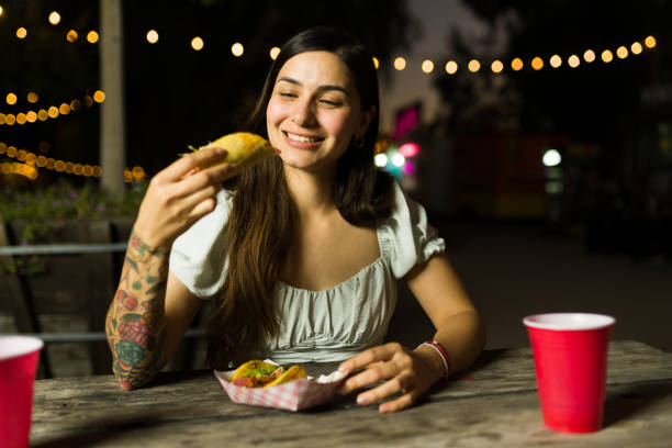 istock Happy young woman eating mexican tacos 1437527653