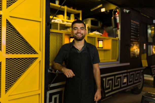 istock Cheerful food truck worker smiling working at night 1437527709