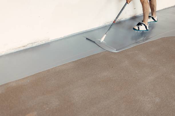 istock Construction worker apply grey epoxy resin in an industrial hall 1437527733
