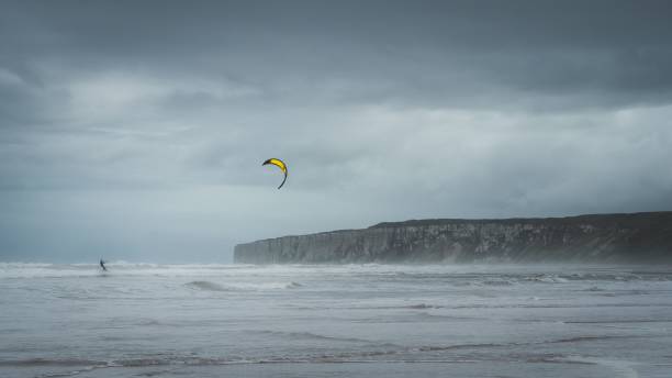 istock Man kitesurfing in the ocean with restless waves on a stormy day 1437527767