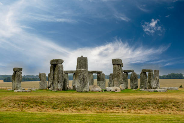 flüsternde wolken am blauen himmel hinter dem steinkreis in stonehenge, einem unesco-weltkulturerbe in der nähe von amesbury in wiltshire, england - prehistoric antiquity stock-fotos und bilder