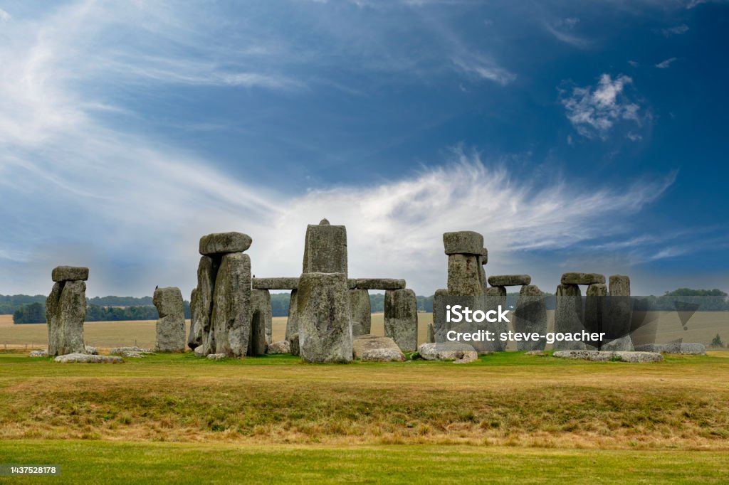 Whispy clouds in a blue sky behind the stone circle at Stonehenge, a UNESCO World Heritage site near Amesbury in Wiltshire, England Daytime view of the stone circle at Stonehenge, a UNESCO World Heritage site near Amesbury in Wiltshire, England Wiltshire Stock Photo