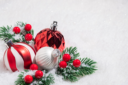 Red and White Christmas balls on snow.