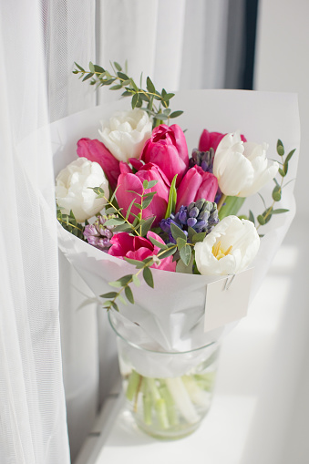Beautiful bouquet with pink tulips and blue hyacinth on a windowsill