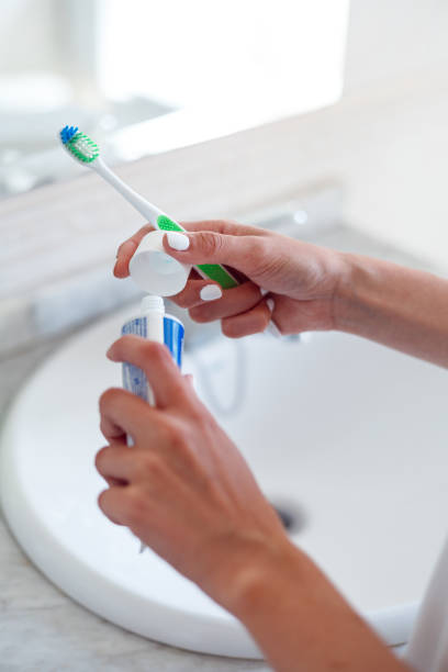 istock Woman hands holding toothpaste and toothbrush 1437530515