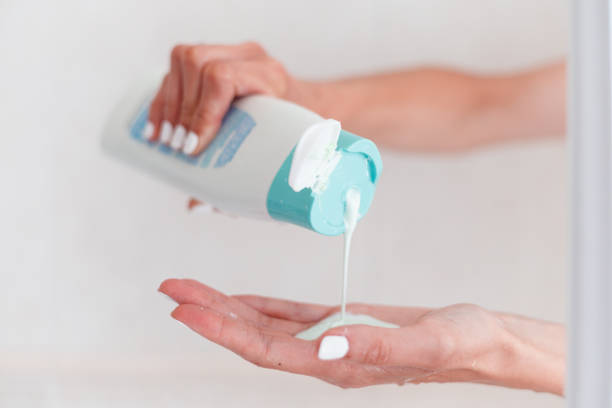 woman pouring body care lotion from bottle into her hand, closeup view, copyspace - shampoo imagens e fotografias de stock