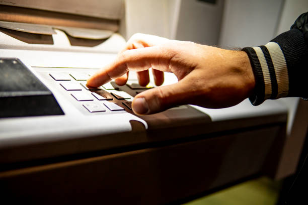 Caucasian guy typing a pin at an ATM