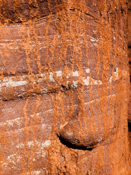 istock Weathered red rock residue running over a sandstone rock face. 1437535867