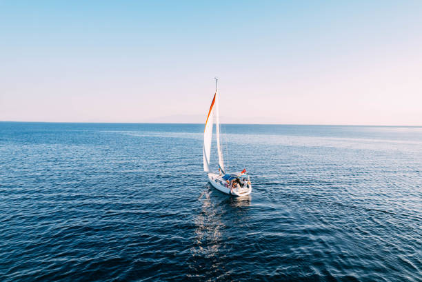 Aerial View Sailboat Moving on the Sea Aerial View Sailboat Moving on the Sea sailing stock pictures, royalty-free photos & images