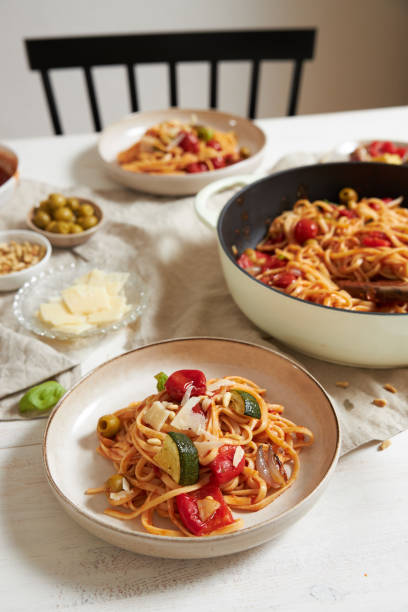 istock Vertical shot of pasta with vegetables and ingredients on a white table 1437539258
