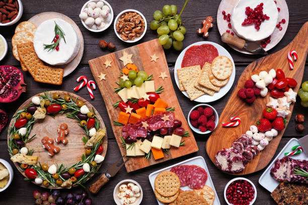 escena de mesa de charcutería navideña sobre un fondo de madera oscura - cheese antipasto cracker grape fotografías e imágenes de stock