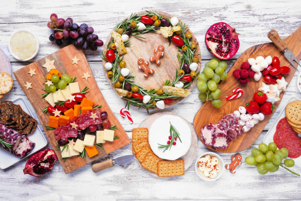 escena de mesa de charcutería navideña sobre un fondo de madera blanca - cheese antipasto cracker grape fotografías e imágenes de stock