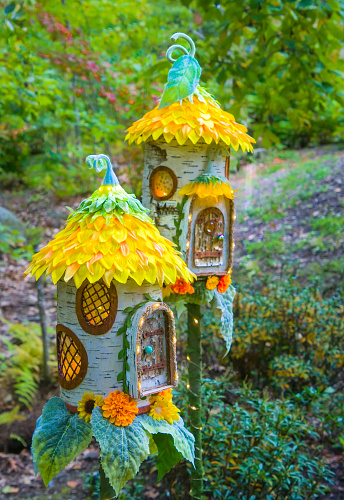 A pair of decorated fairy houses in a New England garden.