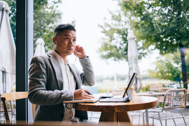 istock Handsome Businessman Talking On A Video Call Using A Digital Tablet And Earphones In The Cafe 1437543308