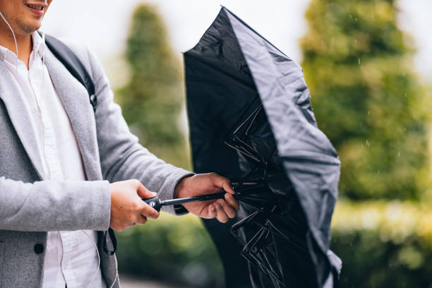istock An Anonymous Asian Businessman Unfolding Umbrella On A Rainy Day 1437543332