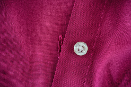 An unbuttoned magenta shirt. Close up.