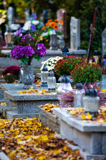 istock Candles and flowers on graves in the cemetery during the All Saint's Day. 1437547596