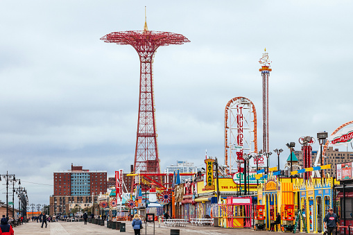 Coney Island, Brooklyn, NY, USA - A few people walking down the famous boardwalk.