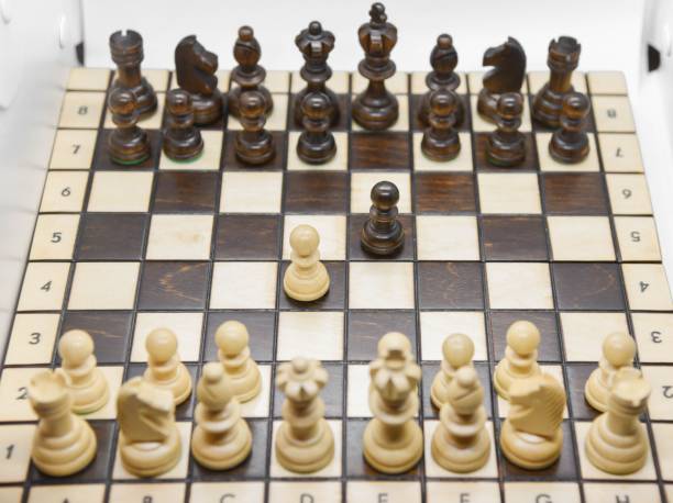 istock Black and white wooden figures for chess on the board 1437555079
