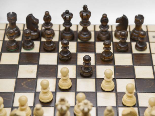 istock Black and white wooden figures for chess on the board 1437555085