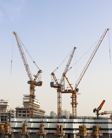 Dubai, United Arab Emirates – July 26, 2020: Big cranes at construction sites in the city centre of Dubai in the United Arab Emirates