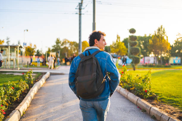 Adult student with backpack, walking in city