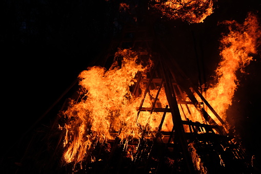 Wooden rural house is burning in fire at night.
