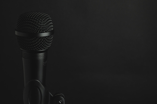 A closeup shot of a black microphone on a black background