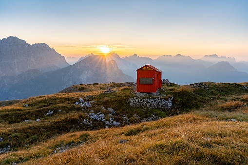 The Bivacco Bedin mountain cabin in the Dolomites mountains at sunset in Italy