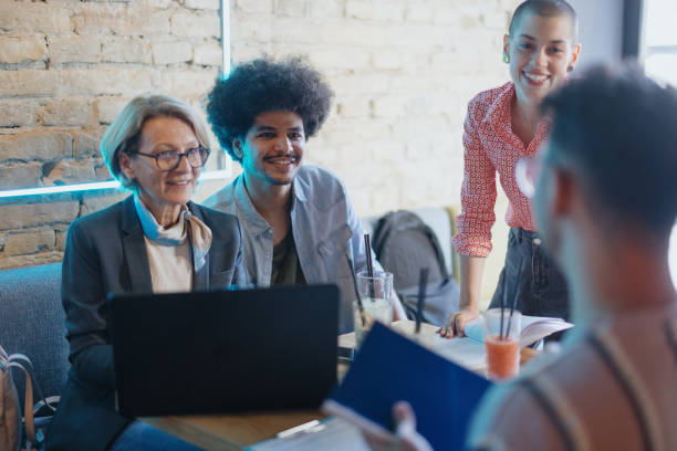 istock University teacher talking to her students at coffee shop 1437565836