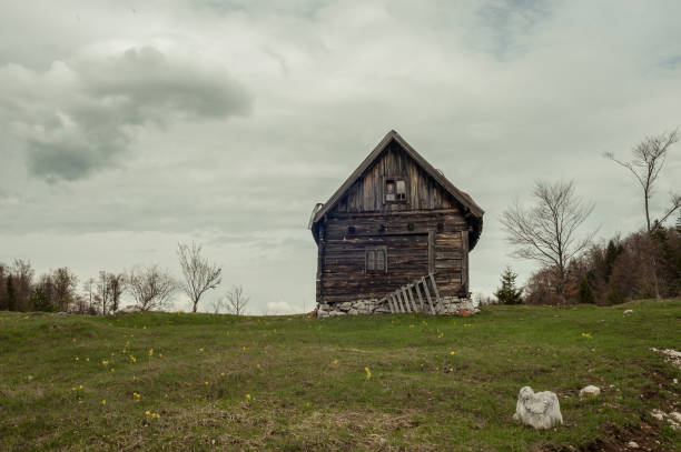 Mountain dust road and abandoned wooden house