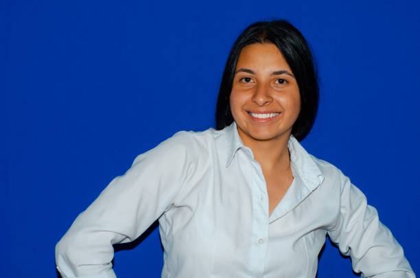 istock Elegant woman looking at camera smiling with blue background 1437566967