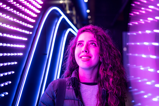 Image of a caucasian girl looking at the purple light while smiling
