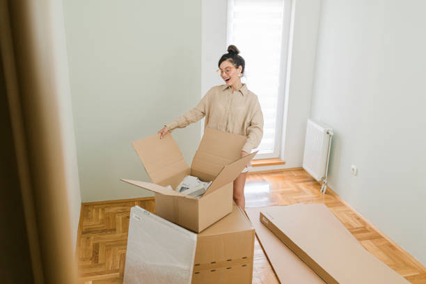 istock One woman, young lady moved into her new apartment, unpacking boxes alone. 1437573017