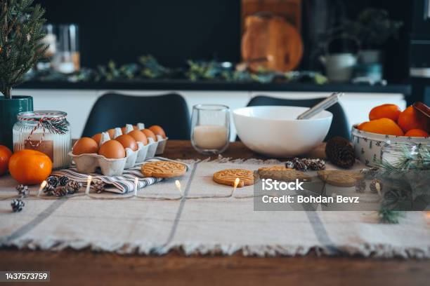 Ingredients For Making Christmas Cookies On The Table Against The Backdrop Of The Kitchen Plate With Dough Milk Egg And New Years Decor Stock Photo - Download Image Now