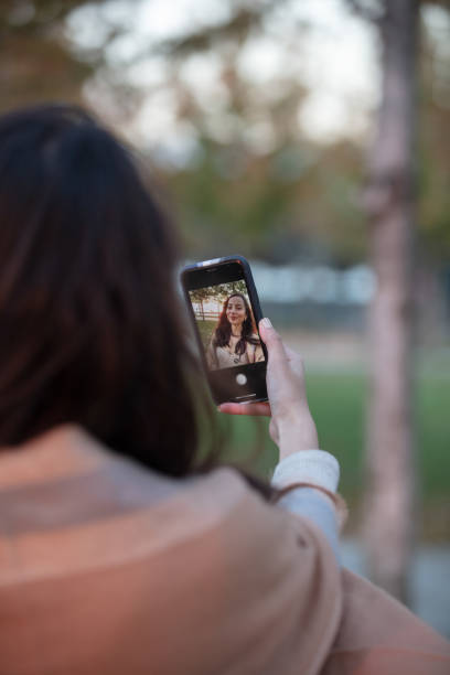 istock Beautiful brunette woman taking selfie at sunset. 1437574712