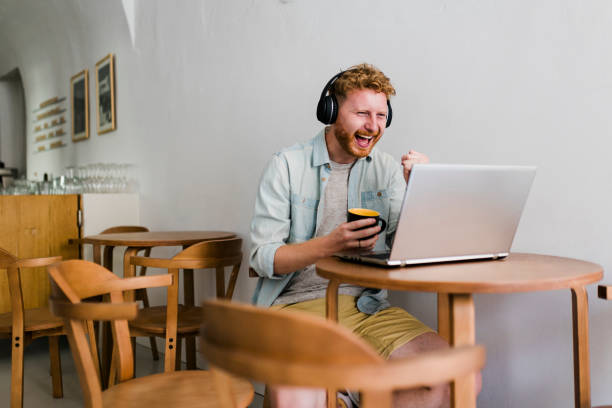 istock Ginger businessman using laptop and having video call at coffee shop 1437576751