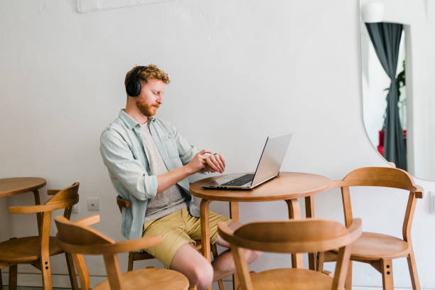 istock Ginger businessman using laptop and having video call at coffee shop 1437576894