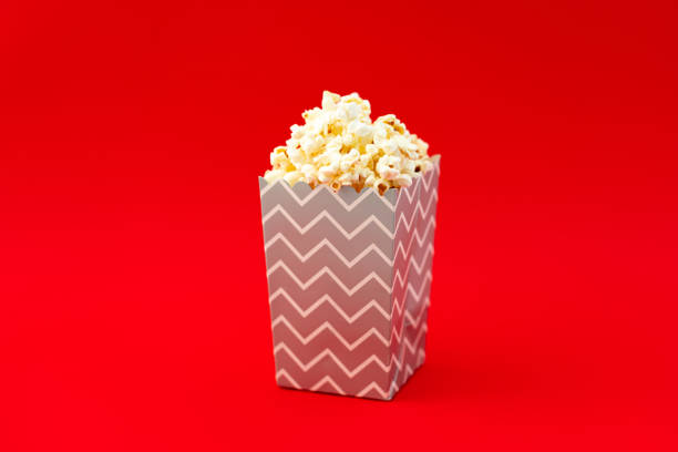 istock Paper box with fresh popcorn on a red background 1437581176