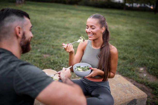 istock Happy sporty couple eating vegetable salad after intensive workout 1437581237