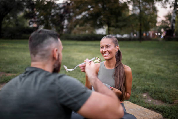 glückliches sportliches paar isst gemüsesalat nach intensivem training - eating body building muscular build vegetable stock-fotos und bilder