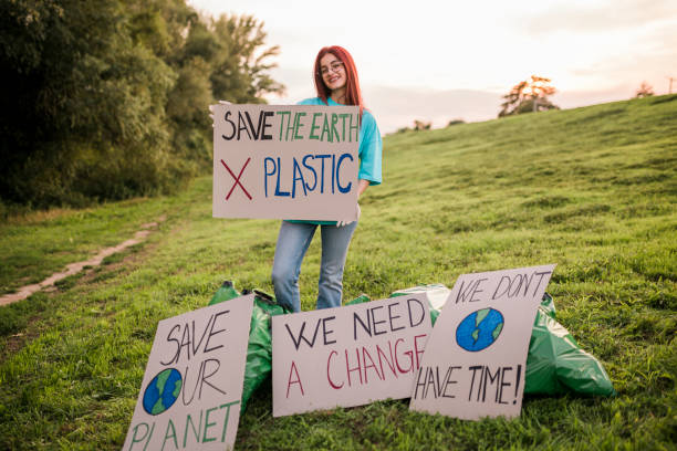 istock Woman holding banner signs while going to a demonstration against climate change. Protest against global warming. Climate change protest concept. 1437584202