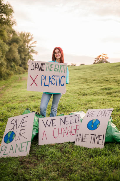 istock Woman holding banner signs while going to a demonstration against climate change. Protest against global warming. Climate change protest concept. 1437584224